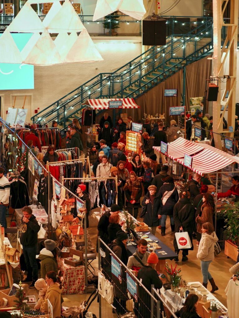 Explore the lively Christmas market atmosphere in Bratislava with people shopping and enjoying the festive stalls.